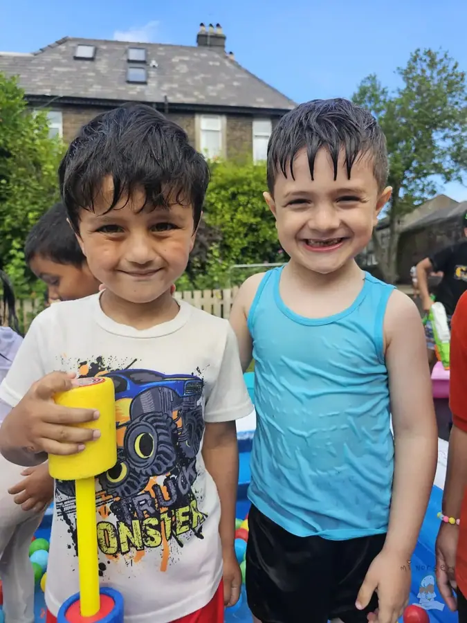 Two children smiling in the nursery garden