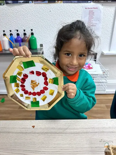 A girl proudly holding up a craft she made
